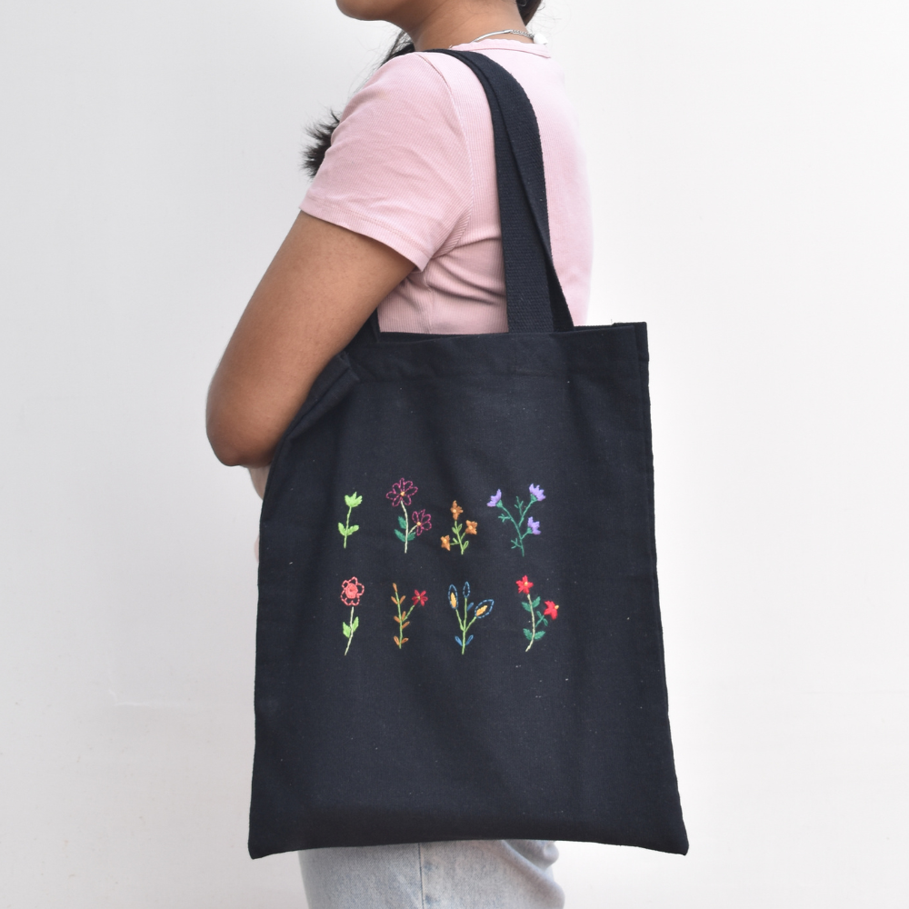 Black canvas tote bag with small flower embroidery