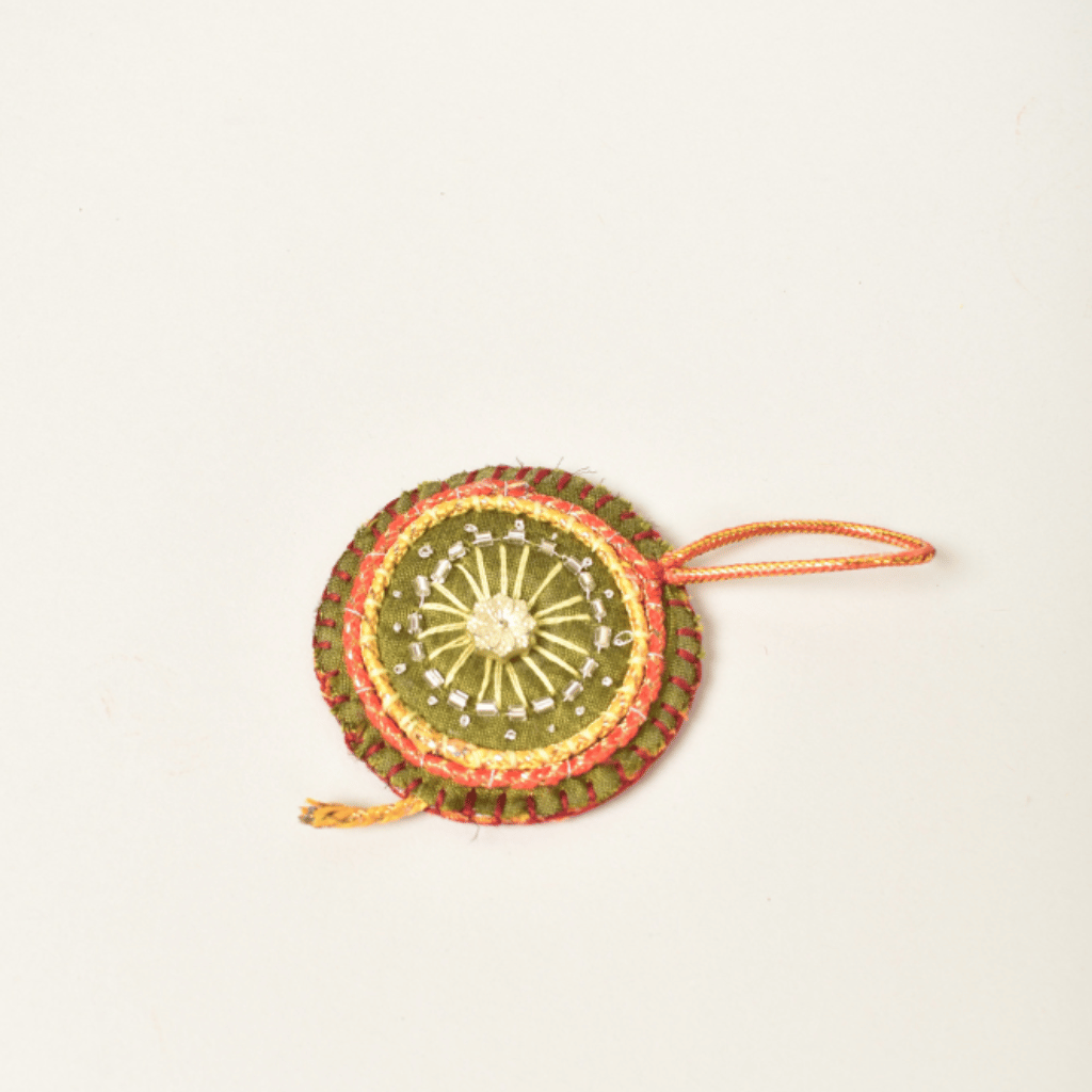 Handmade fabric keychain shaped like Diwali Chakri cracker – festive accessory